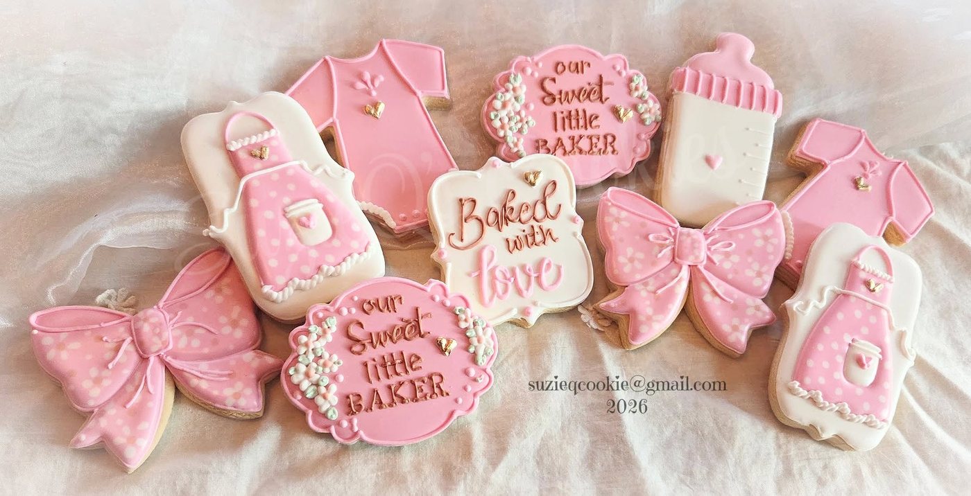 Pink baby shower cookies with bows, onesies and bottles